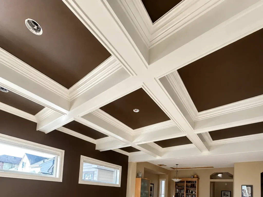Elegant coffered ceiling with dark brown painted panels, white trim, and professionally painted walls in a spacious custom home.
